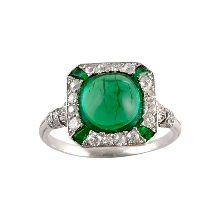 Art Deco cabochon emerald and diamond cluster ring, c.1920, the Colombian emerald of approximately 2.50ct, cushion shaped outline and domed finish,